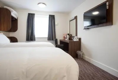 a hotel room with two beds and a mirror at Sweet Chestnut, Dunfermline by Marston's Inns in Dunfermline