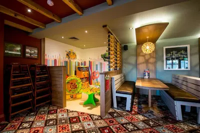a childrens play room with a toy refrigerator and a table at Sweet Chestnut, Dunfermline by Marston's Inns in Dunfermline