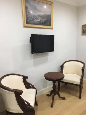 a room with two chairs and a table and a tv at Lanark Residence in Edinburgh