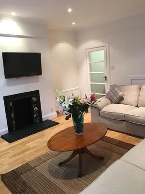 a living room with a couch and a table with flowers at Lanark Residence in Edinburgh