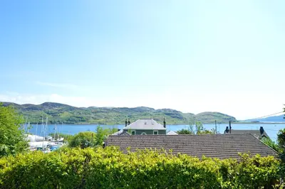 a house with a view of a body of water at Aldersyde in Tighnabruaich