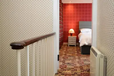 a hallway leading to a bedroom with a bed at Ardmun House in Dunoon