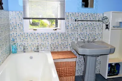 a bathroom with a sink and a tub next to a bath tub at Ardmun House in Dunoon