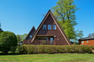 a large wooden house with a gambrel roof at Loch View Lodge in Dunoon