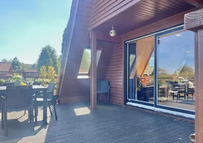 a deck with a table and chairs and a glass window at Loch View Lodge in Dunoon