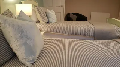 two beds with white pillows in a hotel room at Crofthead Farm House in Tarbolton