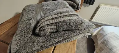 a gray blanket sitting on top of a bed at Ben Lomond Cottage in Arrochar
