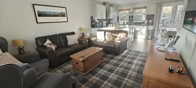 a living room with a couch and a table at Ben Lomond Cottage in Arrochar