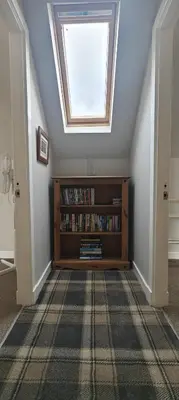 a skylight in a room with a book shelf at Ben Lomond Cottage in Arrochar