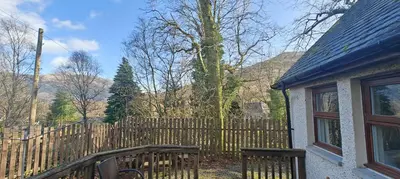 a wooden fence in front of a house at Ben Lomond Cottage in Arrochar