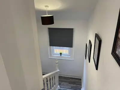 a hallway with a window and a flat screen tv at Elder Park Apartments in Glasgow