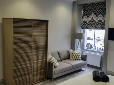 a living room with a couch and a large cabinet at Edinburgh Nine in Edinburgh
