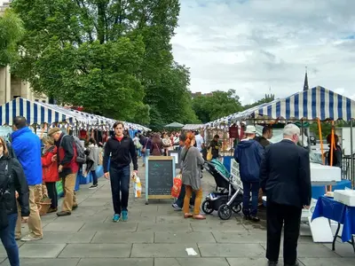 a crowd of people walking around a market with tents at Edinburgh Nine in Edinburgh