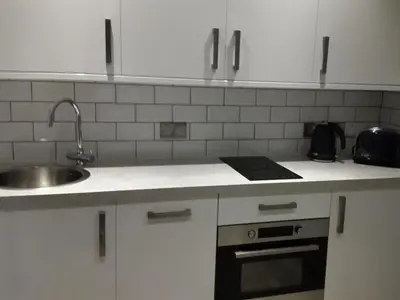 a kitchen with white cabinets and a sink and a stove at Edinburgh Nine in Edinburgh
