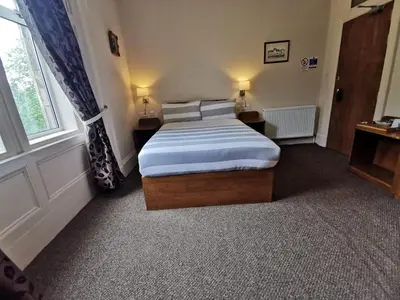 a bedroom with a bed and a window at Bonkle House in Wishaw