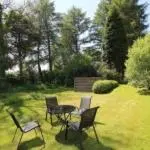 a patio with chairs and a table in a yard at Garden Cottage in Gartocharn