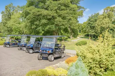 a row of golf carts parked in a park at The Pines - Luxury 3-Bed Apartment Near Golf & Spa, Gleneagles, Auchterarder in Auchterarder