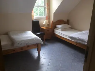 a bedroom with two beds and a window at Riverside Cottage B&B in Cladich