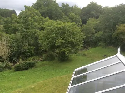 a view from the balcony of a house with trees at Riverside Cottage B&B in Cladich