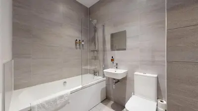 a bathroom with a toilet and a sink and a shower at Glassford Residence in Glasgow