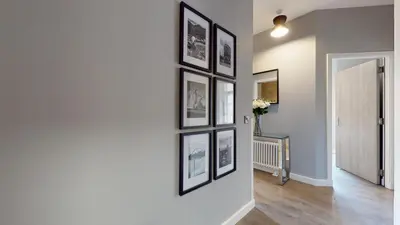 a hallway with several framed pictures on a wall at Glassford Residence in Glasgow