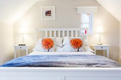 a bedroom with a white bed with two trees on it at JustB Edinburgh in Edinburgh