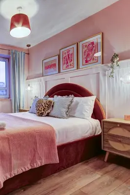 a bedroom with a large bed with pink walls at No5 Ayr Beach - Coorie Doon Stays in Ayr