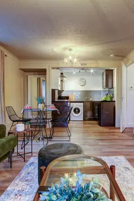 a living room and kitchen with a table and chairs at No5 Ayr Beach - Coorie Doon Stays in Ayr
