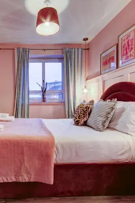 a bedroom with a bed with pillows and a window at No5 Ayr Beach - Coorie Doon Stays in Ayr