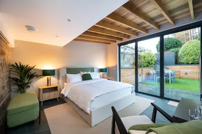 a bedroom with a bed and a large window at Garden Rooms Edinburgh in Edinburgh