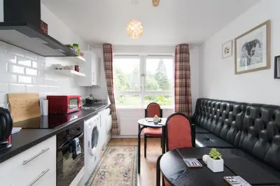 a kitchen with a couch and a table in a room at Norwood Guesthouse-Loch Lomond in Balloch