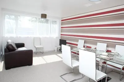 a dining room with a red and white striped wall at Southside Apartment Glasgow in Glasgow