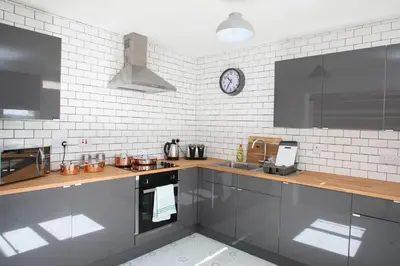 a kitchen with a counter and a clock on the wall at Southside Apartment Glasgow in Glasgow
