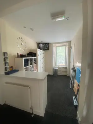 a room with a counter and a clock on the wall at Edinburgh West Side Hostel in Edinburgh