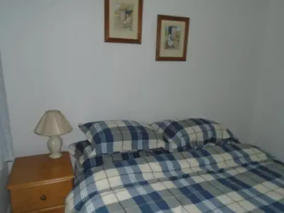 a bed with two pillows and a lamp on a night stand at Fonn Na Mara in Campbeltown