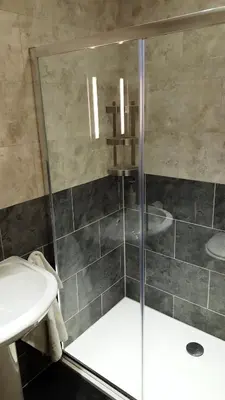 a bathroom with a shower and a sink at Boat House Super Suites in Rothesay