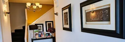 a hallway with pictures on the wall and a shelf at Boat House Super Suites in Rothesay