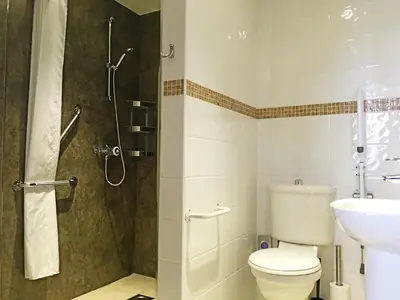 a bathroom with a shower and a toilet and a sink at Boat House Super Suites in Rothesay