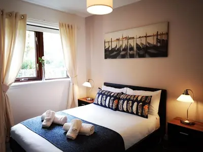 a bedroom with a bed with two towels on it at Mycosy 605 in Paisley