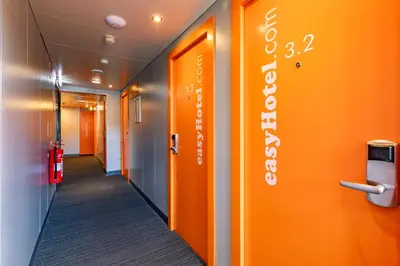 an office hallway with orange walls and a sign on the wall at easyHotel Edinburgh in Edinburgh