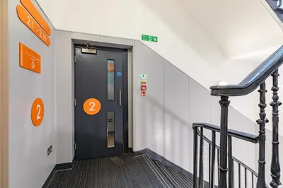 a hallway with a door in a building with stairs at easyHotel Edinburgh in Edinburgh