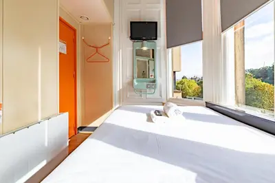 a large white bed in a room with a window at easyHotel Edinburgh in Edinburgh