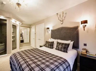 a bedroom with a large bed and a bathroom at Barony Castle Hotel in Peebles