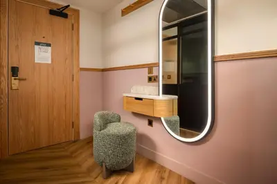 a dressing room with a chair and a mirror at Carlton George Hotel in Glasgow