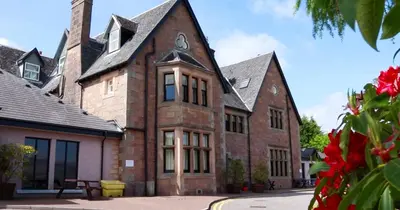 an old brick building with a clock on it at Loch Fyne Hotel & Spa in Inveraray