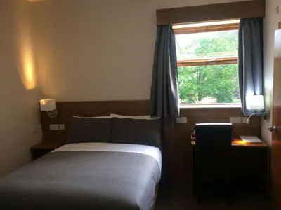 a bedroom with a bed and a window at Crosshill House in Glasgow