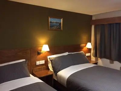 a hotel room with two beds and two lamps at Crosshill House in Glasgow
