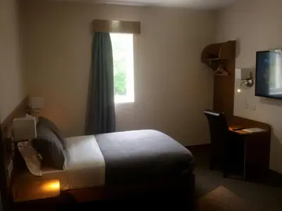 a hotel room with a bed and a window at Crosshill House in Glasgow