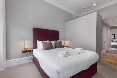 a bedroom with a large bed with white sheets at Destiny Scotland - Distillers House in Edinburgh