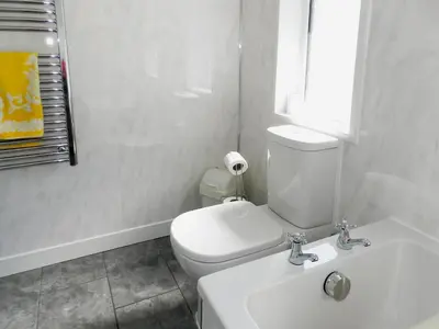 a white bathroom with a toilet and a sink at The Shieling in Lochranza